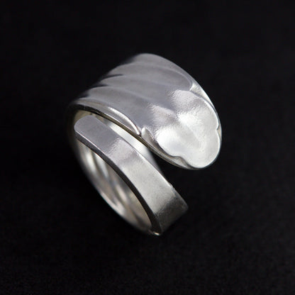 Silver ring with a textured design on a black background