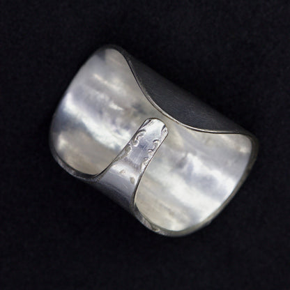 Silver ring with a textured surface on a black background