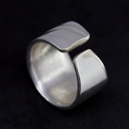 Silver ring with a unique design on a black background
